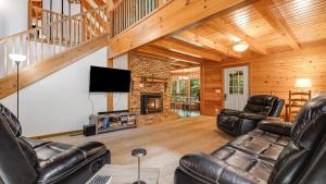 a living room with leather furniture and a fireplace at Twin Creeks Lodge by AvantStay 33 Acre Retreat in Brevard