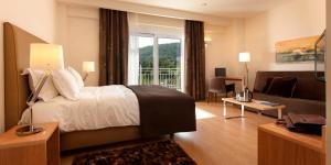 a hotel room with a bed and a couch at Chloe Luxury Hotel in Kastoria