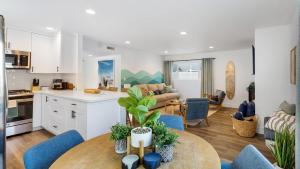 ニューポートビーチにあるCoastal-Chic Newport Stay Steps to the Beach Dining Boardwalk Optional Add-On Unitのキッチン、リビングルーム(テーブル、青い椅子付)