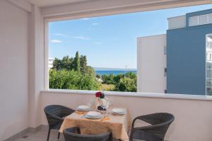 un tavolo e sedie in un balcone con una grande finestra di Luxury Rooms Near the Beach a Spalato (Split)