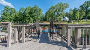 a deck with chairs and a view of a park at Lake Escape by AvantStay Lakefront Private Dock in Mooresville