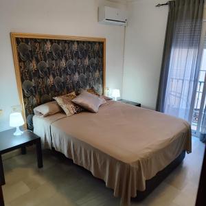 a bedroom with a large bed with a large headboard at PUERTO I Playa in Fuengirola