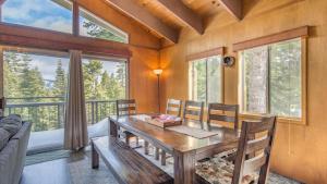 jadalnia z drewnianym stołem i oknami w obiekcie Mahogany by AvantStay Snowbird Cabin w Full Chamberlands Access w mieście Homewood