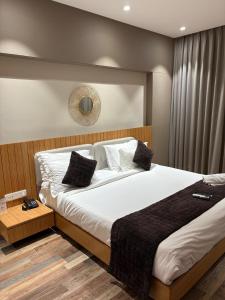 a bedroom with a large bed with white sheets and pillows at Hotel Fortune Mandsaur in Mandsaur