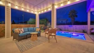a patio with a couch and a table and a pool at Monte Kristeaux by AvantStay Private Pool in Port Aransas