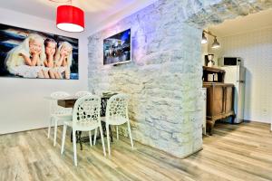 a dining room with a stone wall and a table and chairs at Heart of Kalamaja Apartment in Tallinn