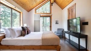 a bedroom with a bed and a tv and windows at Timberline by AvantStay Stunning Chalet Cabin w Hot Tub Pool Table Home Theater in Tahoe Vista