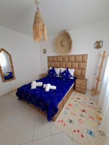a bedroom with a bed with a blue comforter at Essaouira Stay with private Terrace in Essaouira