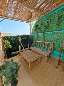 a patio with a bench and a green wall at Essaouira Stay with private Terrace in Essaouira
