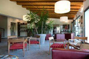 a restaurant with tables and chairs and plants at Residenza Del Parco in Vigevano