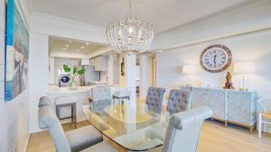 ein Esszimmer mit Tisch und Stühlen und einer Uhr in der Unterkunft 4407 Ocean Club by AvantStay Ocean Views w Community Pool Access - JanFeb Monthly Options Avail in Isle of Palms