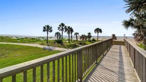 eine Promenade, die zum Strand mit Palmen führt in der Unterkunft 4407 Ocean Club by AvantStay Ocean Views w Community Pool Access - JanFeb Monthly Options Avail in Isle of Palms