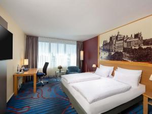 a hotel room with a bed and a desk at Mercure Hotel Berlin Tempelhof in Berlin +79 photos