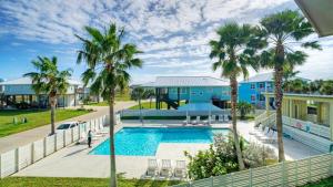una piscina con palme di fronte a una casa di Nature Preserve View Shared Pool Outdoor Living Casa Pescadora by AvantStay a Port Aransas