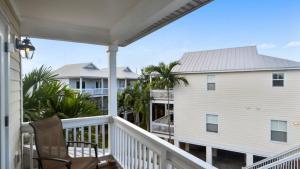 a porch with a chair and a house at Coral Garden by AvantStay Great Location w Balcony Shared Pool in Stock Island