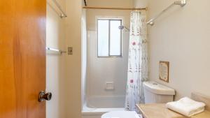 a bathroom with a toilet and a shower curtain at Mutiny Bay Waterfront Cabin by AvantStay Views in Freeland +16 photos
