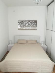 biała sypialnia z dużym łóżkiem i 2 stolikami nocnymi w obiekcie Marimar apartments w Zagrzebiu