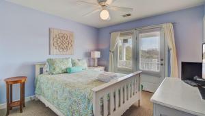 a bedroom with a bed with a ceiling fan and a window at 7 41st Avenue by AvantStay Private Pool Near Beach in Isle of Palms +64 photos