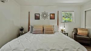 a large white bed in a bedroom with a window at Lake It Right by AvantStay Lakefront w Dock Hot Tub Fire Pit Game Room in Long Pond