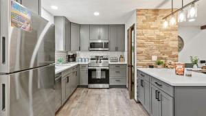 Crescent LakeThe Bears Den by AvantStay Prime Location Renovated w Movie Game Room的厨房配有不锈钢用具和灰色橱柜