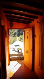 an orange hallway with an open door and a patio at Casa Los Manantiales in Tejeda +15 photos