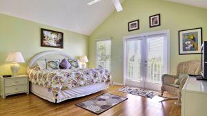 a bedroom with a bed and a chair and windows at Duval Breeze by AvantStay Great Location Close to Beach Nightlife Shared Pool Week Long Stays in Key West +14 photos