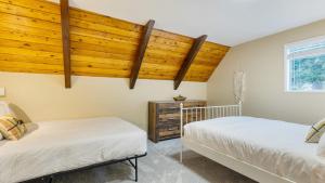 two beds in a room with wooden ceilings at Polnell Point Lookout by AvantStay Water Views Hot Tub Large Patio in Oak Harbor