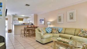 Una sala de estar con un sofá y una cocina. en Breezy Bungalow by AvantStay Close 2 Zachary Taylor State Park Beach w Shared Pool Week Long Stays, en Key West