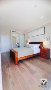 a large bedroom with a large bed and a mirror at KozyGuru | Wentworthville | 2 Bed 2 Bath Apt in Wentworthville