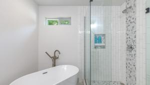 a white bathroom with a tub and a shower at Twin Oaks Retreat by AvantStay Mins to Freeland in Langley +28 photos