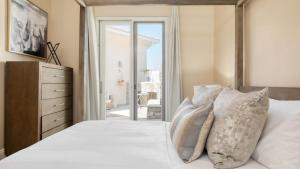 a bedroom with a bed with white sheets and pillows at Camila by AvantStay 18-Person Temecula Mansion in Temecula +52 photos