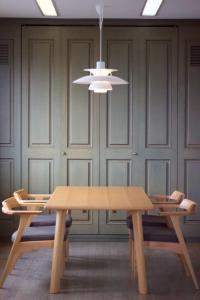 a dining room with a wooden table and a chandelier at Seaside Inn Hokuto in Hokuto
