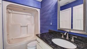 a bathroom with a sink and a toilet and a mirror at Lakefront w Private Dock Hot Tub Pontoon Rental Butler Bliss by AvantStay in Sherrills Ford +30 photos