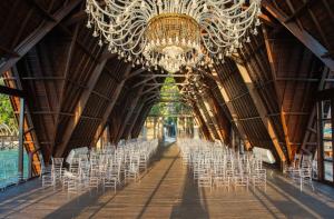 a long hallway with white chairs and a chandelier at Sepa Island Resort in Pulau Tondan Barat