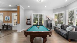 Una sala de estar con una mesa de billar y un sofá. en Laid Back Lake Life by AvantStay Waterfront View, en Mooresville