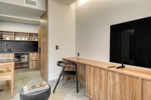 a living room with a tv and a desk with a chair at Namóra by Lumina in Guadalajara