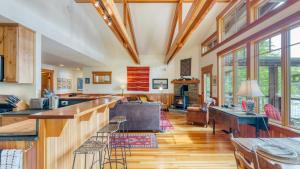 a kitchen and living room with wooden floors and windows at Goss Lake Chalet by AvantStay Lakefront w Dock Fire Pit Outdoor Dining Area in Langley