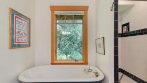 a bath tub in a bathroom with a window at Goss Lake Chalet by AvantStay Lakefront w Dock Fire Pit Outdoor Dining Area in Langley +33 photos