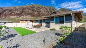 una casa con una montaña al fondo en Makaha Hideaway by AvantStay 10 Minutes to Beach, en Waianae