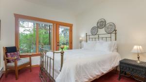 a bedroom with a bed and a chair and a window at Goss Lake Chalet by AvantStay Lakefront w Dock Fire Pit Outdoor Dining Area in Langley