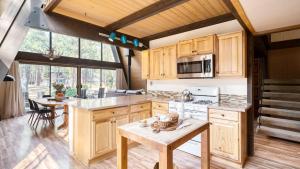 a large kitchen with wooden cabinets and a table at Alder by AvantStay Moody Retreat: Patio Hot Tub in Sunriver in Sunriver