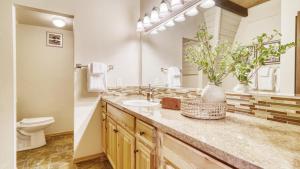 a bathroom with a sink and a toilet and a mirror at Alder by AvantStay Moody Retreat: Patio Hot Tub in Sunriver in Sunriver +35 photos