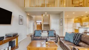 a living room with a leather couch and a table at Forest Ridge Loop by AvantStay Hot Tub Private Community Amenities in Redmond