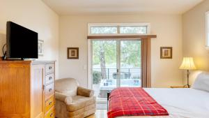 a bedroom with a bed and a tv and a chair at Forest Ridge Loop by AvantStay Hot Tub Private Community Amenities in Redmond