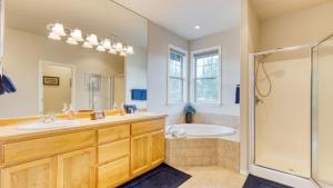 a bathroom with two sinks and a tub and a shower at Forest Ridge Loop by AvantStay Hot Tub Private Community Amenities in Redmond +36 photos