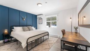 a bedroom with a bed with a blue accent wall at Birchwood by AvantStay Game Room Lake Access in Blakeslee