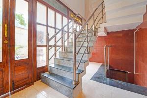 a staircase in a house with a wooden door at Hotel O Sasti Inn in Pondicherry +38 photos