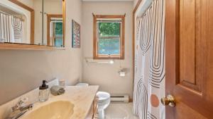 a bathroom with a sink and a toilet and a mirror at Marina Village by AvantStay Walk to Lake Marina Balcony Patio in Greentown +24 photos