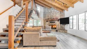 ein Wohnzimmer mit einer Treppe und einer Steinmauer in der Unterkunft Honeypot by AvantStay Indoor Pool Hot Tub in Big Bear Lake