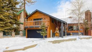ein Holzhaus mit einer Garage im Schnee in der Unterkunft Honeypot by AvantStay Indoor Pool Hot Tub in Big Bear Lake